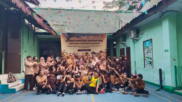 Pengurus OSIS dan para guru berfoto bersama di depan spanduk Pentas Seni dan Market Day