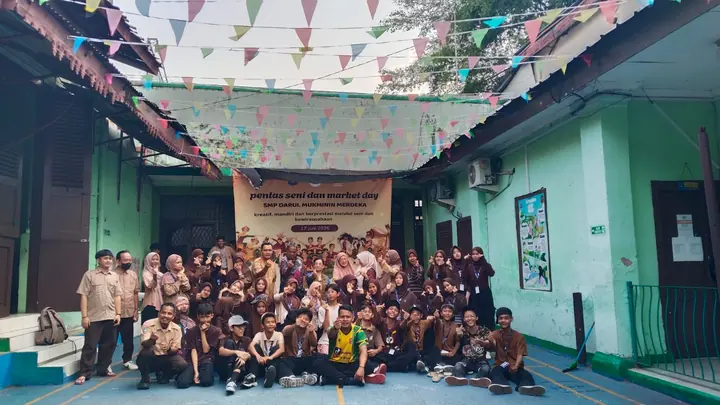 Pengurus OSIS membentuk tanda hati dengan jari di halaman sekolah saat Pentas Seni
